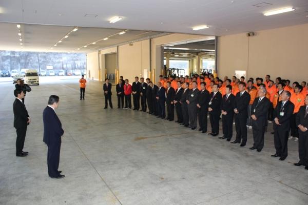 森山農林水産大臣へ向かいスーツの男性が一列目、オレンジのジャンバーを着た生産者達が後方に並んで激励を受ける写真