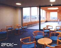 カルム五條館2階ロビーの内観の写真青いじゅうたんに丸い机と青いイスが複数写っている
