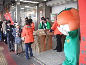 北海道函館市でハッピを着たスタッフとカッキーが柿をPRしている写真