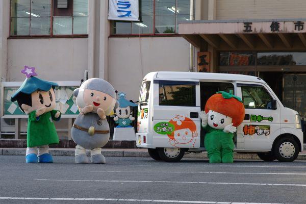 五條市役所前に集まるマスコットキャラクターゴーカスターと五條市のPR用車両の写真