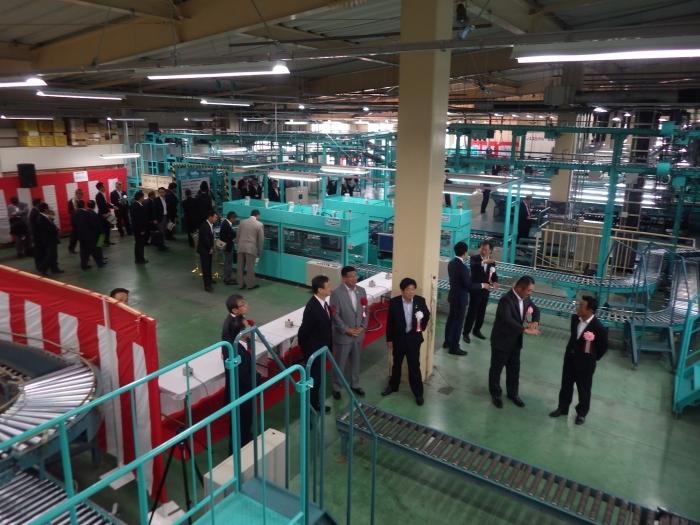 選果場の中を生産者、JA職員、奈良県選出国会議員、行政機関などの関係者で見学している写真