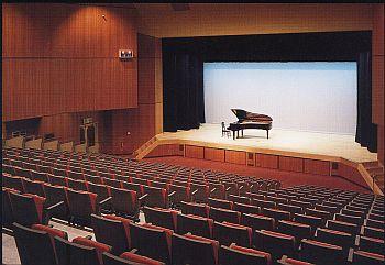 360席あるホール、ステージにはグランドピアノが置いてある写真